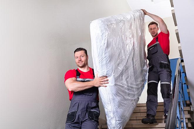 furniture removal experts handling a box spring with care in Lewisburg, OH